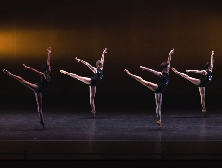 A group of ballerinas performing on stage.